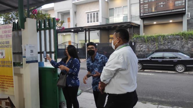 Petugas tatalaksana memastikan umat cek in di aplikasi peduli lindungi---